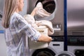 Housework: woman loading clothes into washing machine
