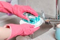 Housework. A woman in pink rubber gloves is washing dishes. Close up of kitchen sink and hands Royalty Free Stock Photo