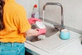 Housework. A woman in pink rubber gloves is washing a plate. Side view. Copy space