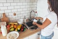 Housework. Young woman washing dishes in kitchen.