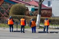 Housing and communal services workers are preparing street sidewalk fence for painting, Gomel, Belarus