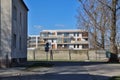 A housing estate of modern apartment blocks with balconies behind a concrete fence