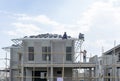 Housing property construction progress, people are building a precast house, the workman working on the roof in a hot day under