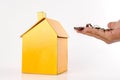 Housing/real estate concept. Hand holds key and house model on white. Royalty Free Stock Photo