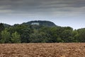 Houska castle in Czech Republic, Bohemia, Europe. State caste, hiden in green forest, dark grey clouds. Tower house in landscape.