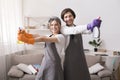 Houskeeping Concept. Happy couple holding spray detergents, posing in home interior