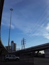 Houston Texas skyline with powerlines, skyscrapers, freeways, wispy clouds and a white car