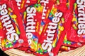 Skittles candy packets scattered loosely in a wicker basket.