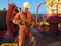 Portrait of sailor in uniform holding steel hawser on board of oil tanker NS Century