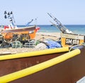 Traditional colourful fishing boats of South England pulled up on beach