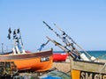 Traditional colourful fishing boats of South England pulled up on beach