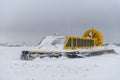 Hovercraft in winter tundra. Air cushion on the beach. Yellow hover craft under snow