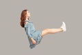 Hovering in air. Full length side view of calm serious brunette pretty girl ruffle dress levitating, looking away Royalty Free Stock Photo