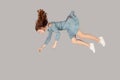 Hovering in air. Relaxed beautiful girl ruffle dress and curly soaring hair levitating, flying in dream with hands up Royalty Free Stock Photo
