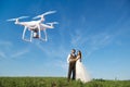 Hovering drone taking pictures of wedding couple in nature Royalty Free Stock Photo