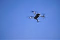 Hovering electronic drone against clear cerulean sky