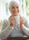 How abour a cup of tea at grandmas house. A happy senior woman enjoying a cup of coffee at her kitchen table - portrait.