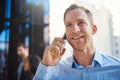 And how can I help you today. a businessman answering his cellphone while standing on a balcony. Royalty Free Stock Photo