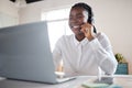 How can we improve your life. a young businesswoman using a headset and laptop in a modern office. Royalty Free Stock Photo