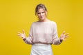 How could you? Portrait of annoyed disappointed young woman with fair hair in casual beige blouse, isolated on yellow background