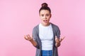 How could you. Portrait of brunette teen girl raising hands asking why, looking indignant displeased. pink background