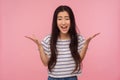 How could you? Portrait of displeased girl with long hair in striped t-shirt raising hands in questioning gesture Royalty Free Stock Photo