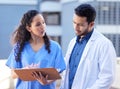 How did this happen. two young doctors checking some paperwork while outside in the city. Royalty Free Stock Photo