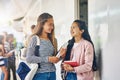 How did you do on the test. two happy schoolgirls chatting in the hallway outside their classroom.