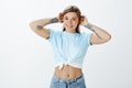 How do you like my new outfit. Portrait of happy charming european female student with tattoos in cropped top and jeans Royalty Free Stock Photo