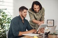 And how does this work. two businessmen using a digital tablet together in an office. Royalty Free Stock Photo