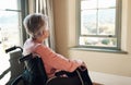 How I wish I had my life back. a senior woman in a wheelchair looking thoughtfully out of a window at home.