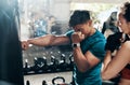 This is how its done. a handsome young male fitness instructor coaching a female boxer in a gym.