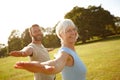 This is how we keep ourselves feeling young. Portrait of a happy mature couple doing yoga together outdoors. Royalty Free Stock Photo