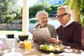 This is how we keep ourselves in the loop. an affectionate senior couple reading the newspaper while enjoying a meal Royalty Free Stock Photo