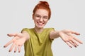 How long I havent seen you. Joyful pretty red haired girl gives warm hug at camera, pulls hands, greets best friend Royalty Free Stock Photo