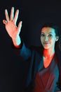 How many fingers am I holding up. Portrait of a young businesswoman showing a number with her fingers against a dark