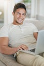 This is how we millennials relax. Portrait of a relaxed young man using a laptop on the sofa at home. Royalty Free Stock Photo