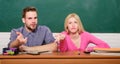 How is it possible. Guy and girl sit at desk in classroom. Wondering about result. Studying in college or university Royalty Free Stock Photo