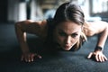 This is how she stays in such great shape. an attractive young woman doing push ups in a gym.