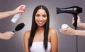 How are we styling your hair today. an attractive young woman standing in the studio while a team of hairstylists style Royalty Free Stock Photo