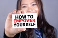HOW TO EMPOWER YOURSELF message on the card shown by a businesswoman Royalty Free Stock Photo