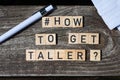 How to get taller question letters on wooden blocks on a wooden table with pencil and paper at the sides of the shot