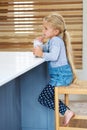 How to grow up big and strong. Full length shot of a cute little girl enjoying a glass of milk at the kitchen counter.