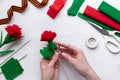 How to make carnation flower at home. Hands making red carnation to Victory Day 9 May. instruction. Step14. Glue green Royalty Free Stock Photo