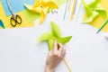 How to make paper green windmill toy with children at home. Step 11. Turn windmill to other side and attach straw to button