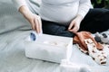 How to Organize Newborn Baby Clothes. Pregnant woman Using ornament boxes, baskets, or dividers to organize baby clothes