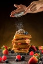 Ã Â¹â¡How to powdering traditional homemade waffles with icing sugar. Waffles with ice cream, caramel sauce and fresh berries. Royalty Free Stock Photo