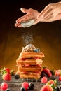 How to powdering traditional homemade waffles with icing sugar. Waffles with ice cream, caramel sauce and fresh berries. Delicious