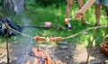 How to roast sausages with vegetables. Sausages on stick bonfire background. Roasty toasty sausages are such Royalty Free Stock Photo