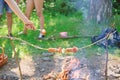 How to roast sausages with vegetables. Sausages on stick bonfire background. Smoky smell of roasted food. Roasty toasty Royalty Free Stock Photo